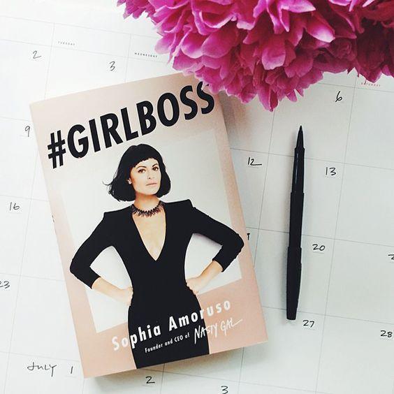 Libro #GIRLBOSS de Sophia Amoruso sobre calendario con flor rosa y bolígrafo negro