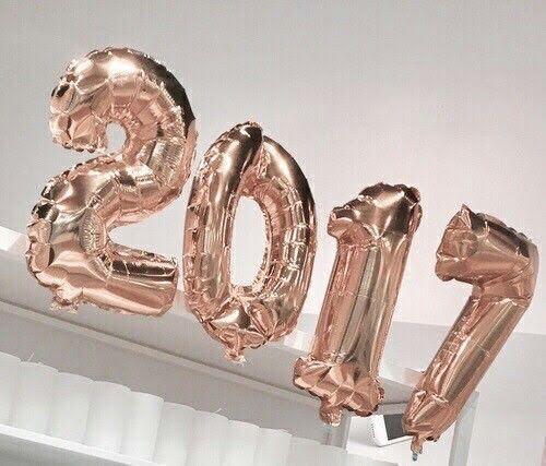 Globos dorados en forma de números 2017 para celebración sobre fondo claro