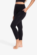 Mujer con leggins negros deportivos con bolsillo lateral y cintura alta, fondo blanco