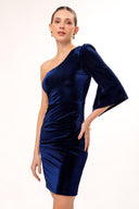 Mujer con vestido azul de terciopelo, corte asimétrico con una manga larga en fondo blanco