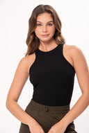 Mujer con cabello castaño lleva top negro sin mangas y pantalón verde caqui con cintura elástica