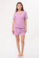 Mujer con pijama corto lila de mezclilla con bordes blancos, fondo blanco